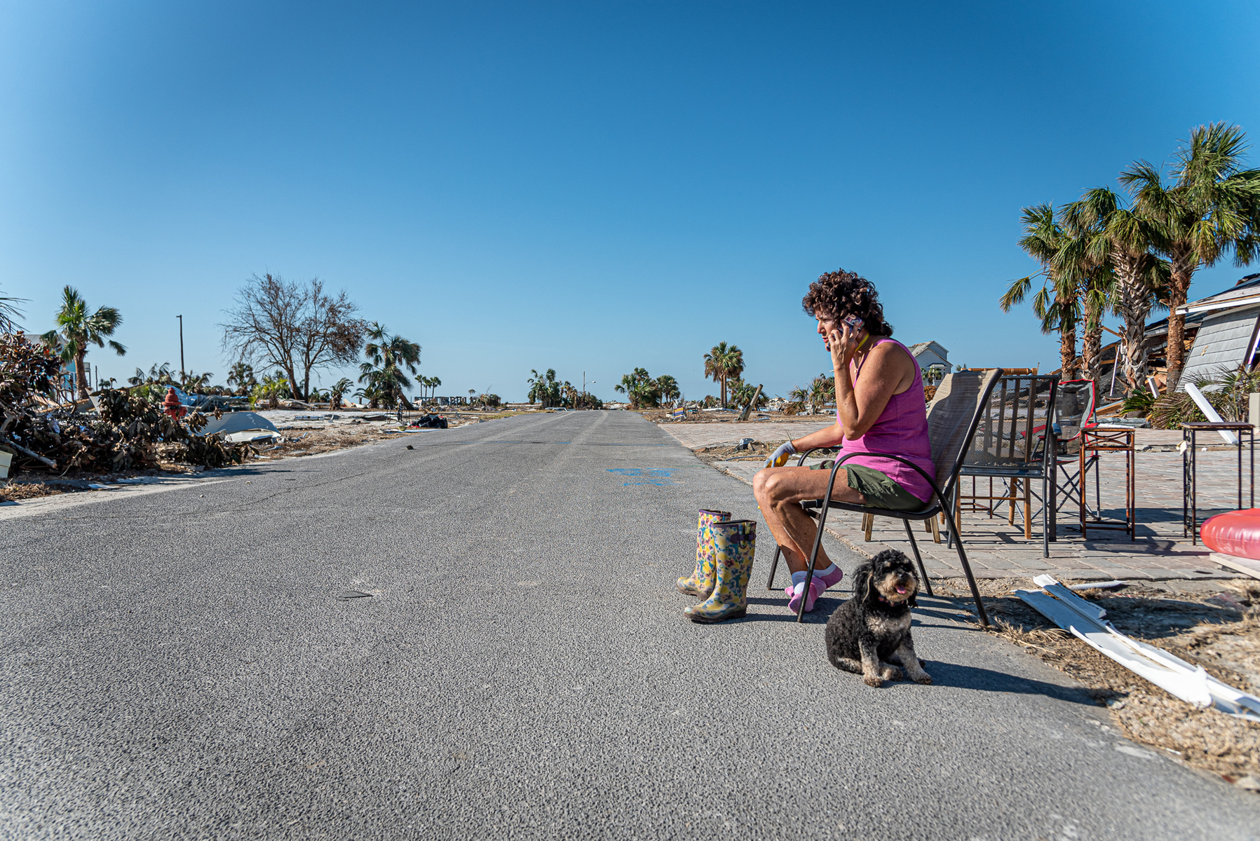 October 18, 2018 - Mexico Beach, FL - A woman talks on the phone in front of she  the remains of her home to see if she can salvage anything after it was destroyed by Hurricane Michael as it passed through the area on October 15, 2018 in Mexico Beach, Florida.  The hurricane hit the Florida Panhandle as a category 4 storm causing massive damage and claimed the lives of more then a dozen people.